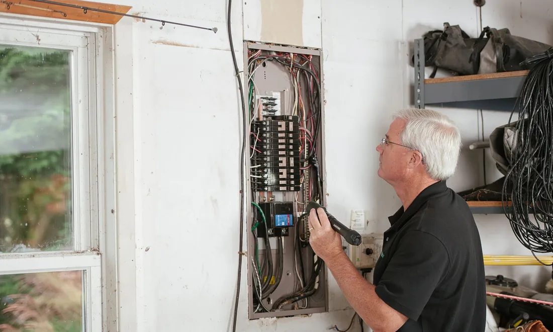 Elektriker prüft einen Sicherungskasten in einem Wohnhaus